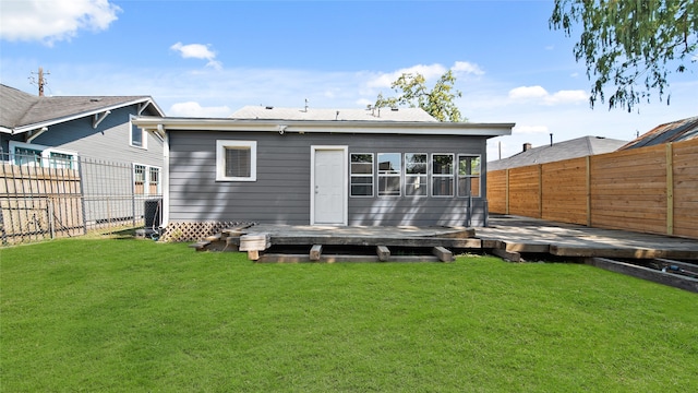 rear view of house featuring a yard and a wooden deck