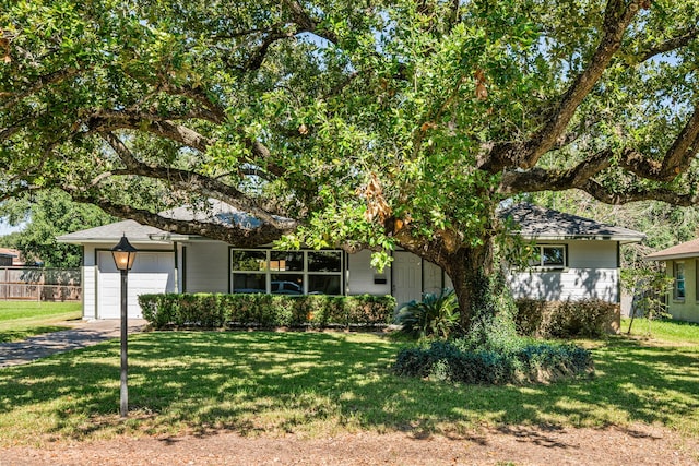 obstructed view of property with a garage and a front yard