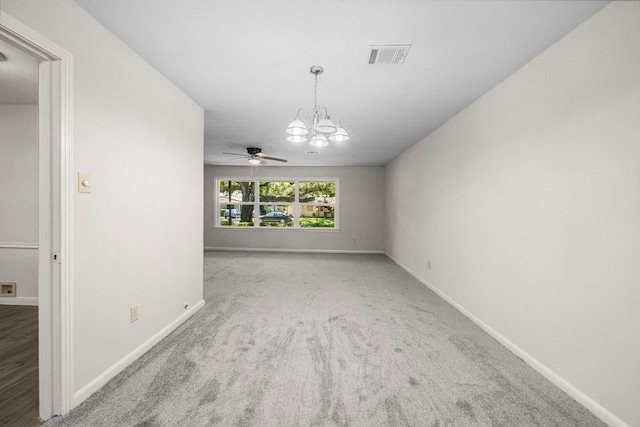 empty room with light carpet and ceiling fan with notable chandelier