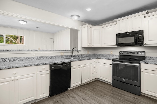 kitchen featuring sink, light stone countertops, dark hardwood / wood-style floors, white cabinets, and black appliances