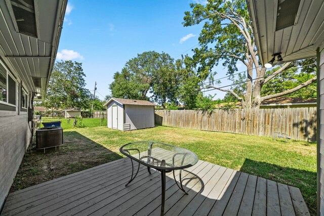 deck featuring central AC unit, a lawn, and a storage unit