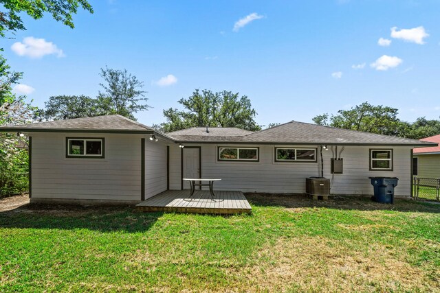 rear view of house with a wooden deck, central air condition unit, and a lawn