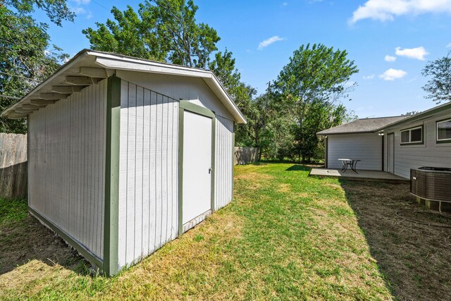 view of outbuilding featuring cooling unit and a yard