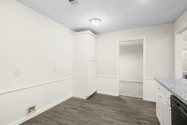 unfurnished dining area featuring a textured ceiling and dark hardwood / wood-style floors