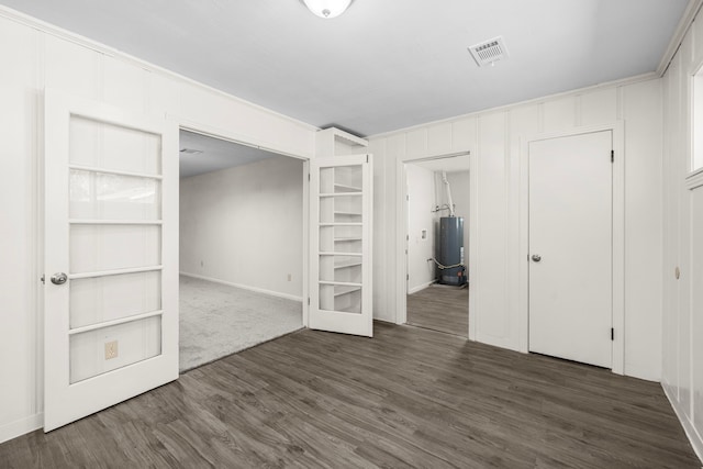 unfurnished bedroom with water heater and dark wood-type flooring