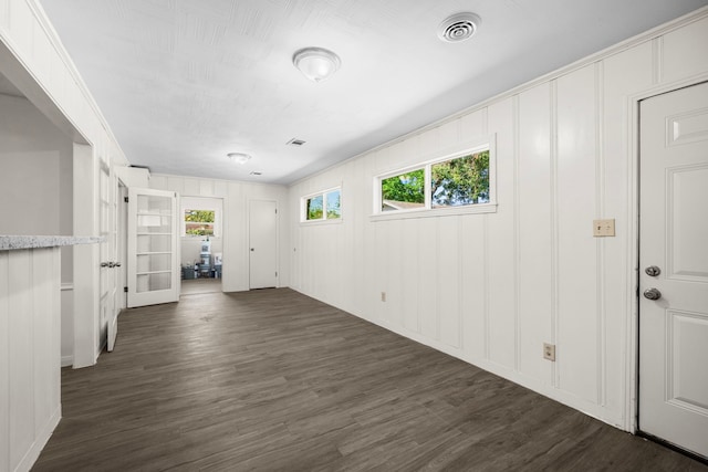 unfurnished room featuring crown molding and dark wood-type flooring