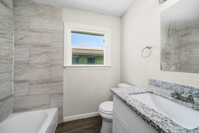 full bathroom with tiled shower / bath, vanity, toilet, and hardwood / wood-style flooring