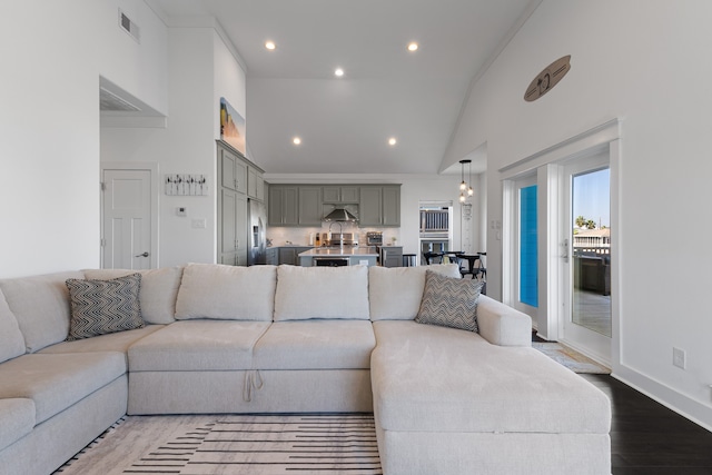 living room featuring ornamental molding, high vaulted ceiling, and wood-type flooring