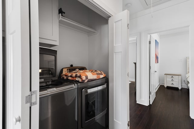 washroom featuring separate washer and dryer, cabinets, and dark hardwood / wood-style flooring