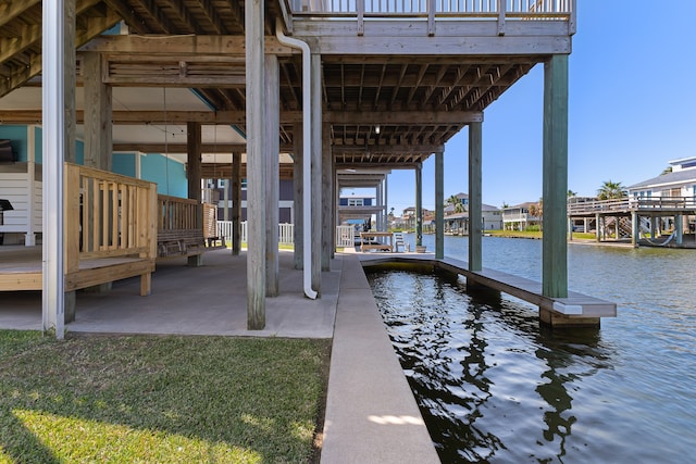 view of dock with a yard and a water view