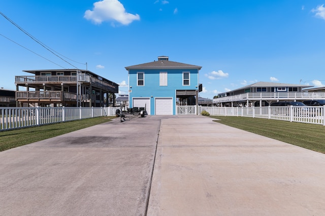 rear view of property featuring a garage and a lawn