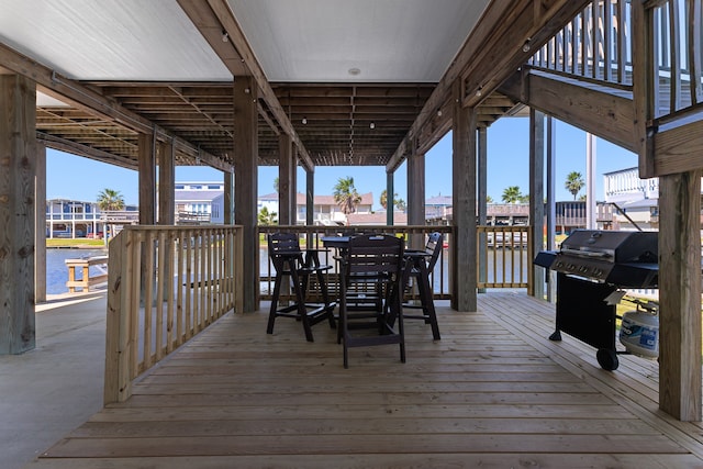 wooden deck with grilling area and a water view