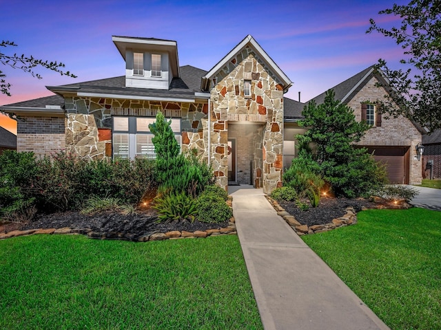 view of front of property with a yard and a garage