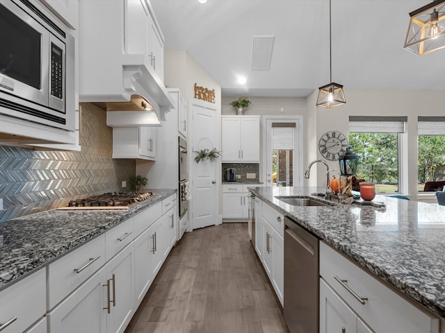 kitchen with white cabinets, stainless steel appliances, hanging light fixtures, and sink