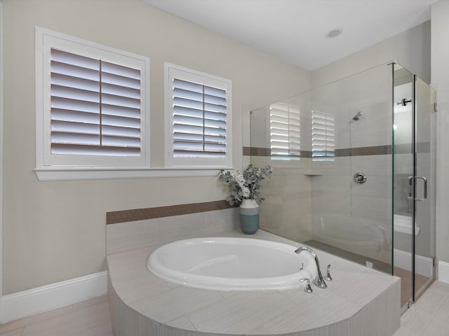 bathroom with separate shower and tub and tile patterned flooring