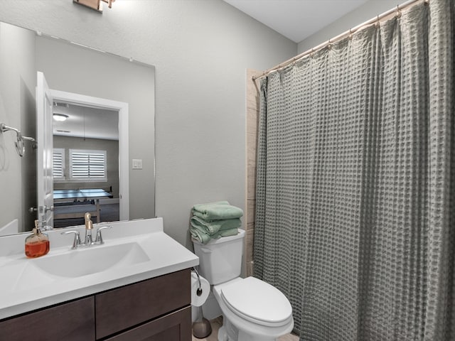 bathroom with vanity, toilet, and curtained shower