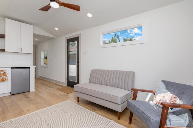 sitting room featuring ceiling fan, light hardwood / wood-style floors, and lofted ceiling