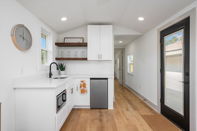 kitchen with white cabinetry, light wood-type flooring, lofted ceiling, and sink