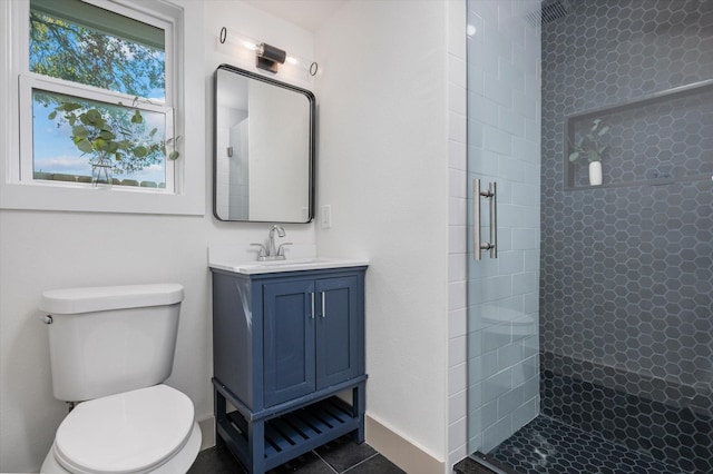 bathroom featuring tile patterned flooring, vanity, toilet, and a shower with shower door