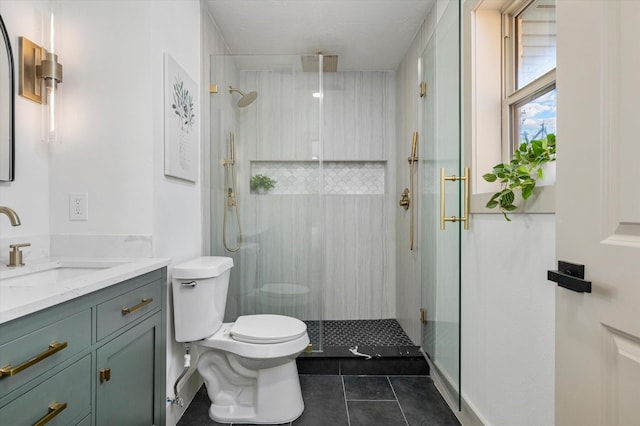 bathroom with tile patterned floors, vanity, toilet, and a shower with shower door