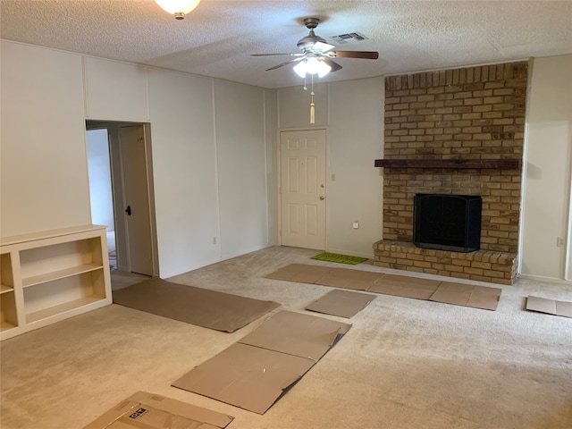 unfurnished living room featuring light carpet, a textured ceiling, a fireplace, and ceiling fan