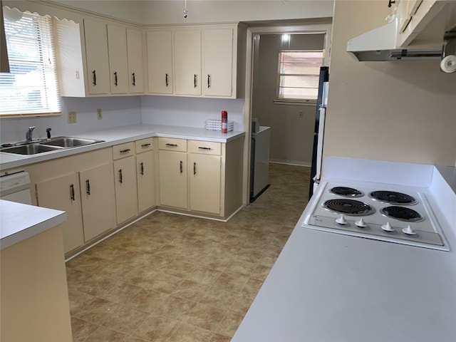 kitchen featuring white appliances, cream cabinets, sink, and a wealth of natural light