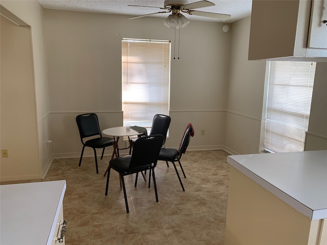 dining space featuring ceiling fan, light tile patterned floors, and a textured ceiling