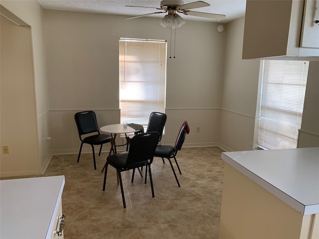 dining room featuring ceiling fan and a textured ceiling