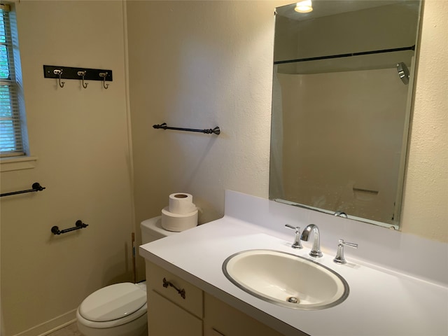 bathroom with vanity, a shower, and toilet