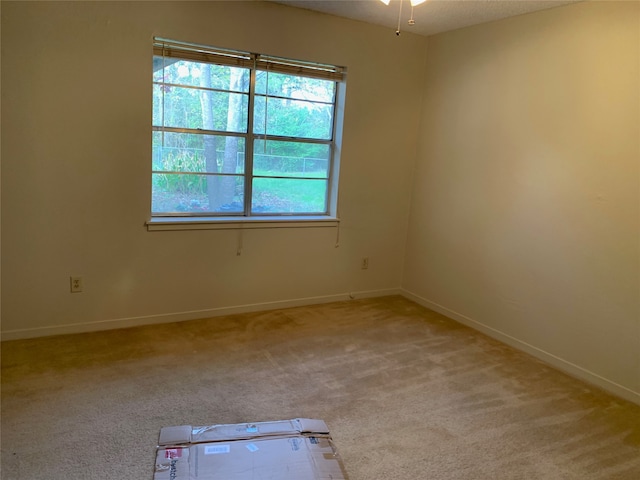 empty room featuring light carpet and ceiling fan