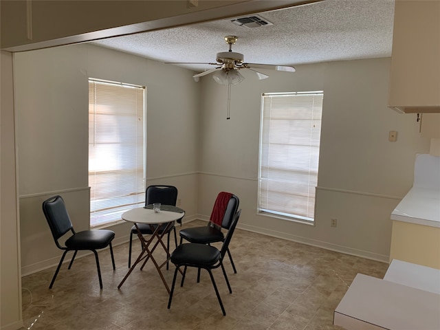 dining room with a textured ceiling and ceiling fan