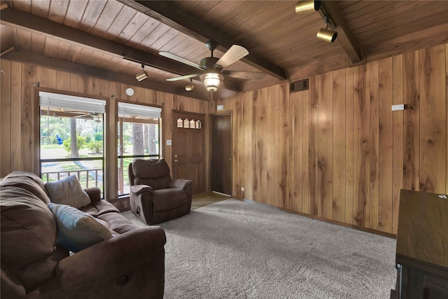 unfurnished living room with track lighting, wooden walls, and beamed ceiling