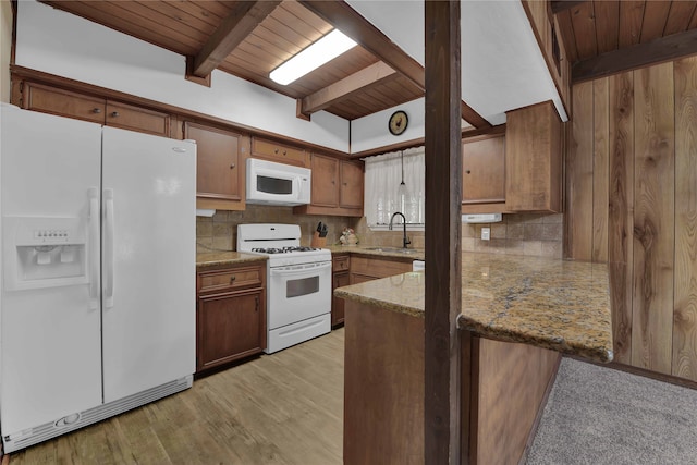 kitchen with sink, wood ceiling, light stone counters, beamed ceiling, and white appliances