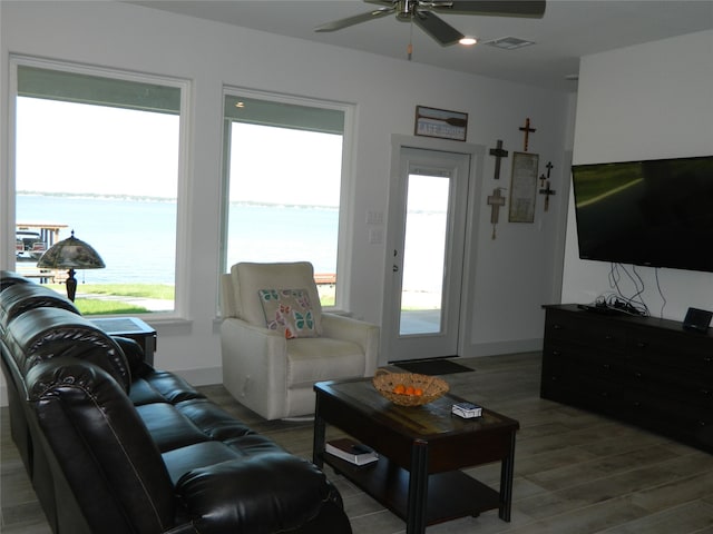 living room featuring a water view, light wood-type flooring, and ceiling fan