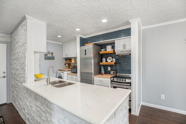 kitchen with dark wood finished floors, a sink, stainless steel appliances, white cabinetry, and backsplash