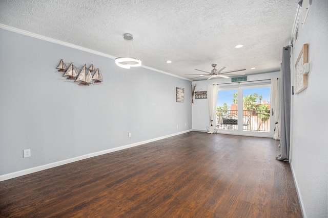 spare room with a textured ceiling, dark wood-type flooring, ornamental molding, and ceiling fan