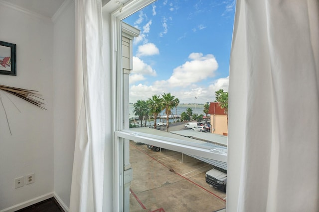 interior space with crown molding, baseboards, and a water view