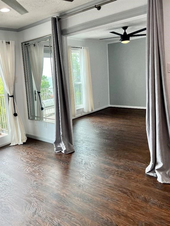 unfurnished room featuring dark hardwood / wood-style flooring, a wealth of natural light, a textured ceiling, and ceiling fan