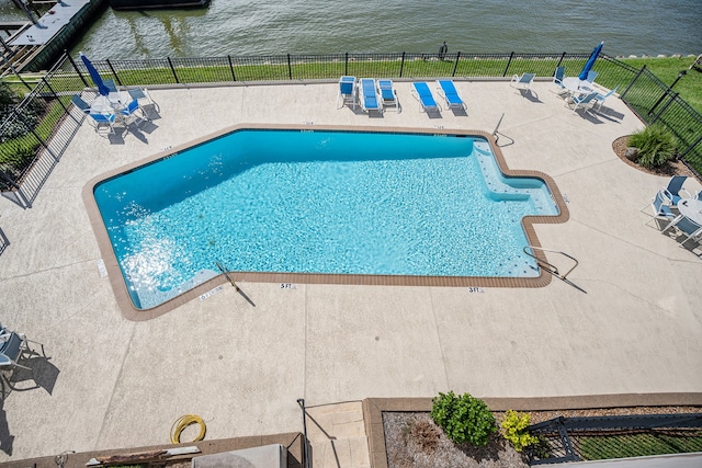 view of pool with a patio and a water view