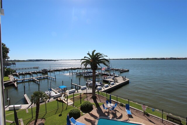 view of dock with a water view and a fenced in pool