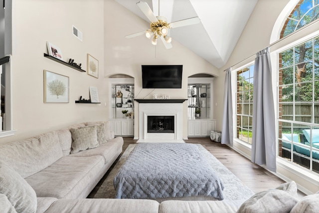 living room with ceiling fan, hardwood / wood-style floors, high vaulted ceiling, and a wealth of natural light