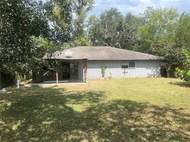 rear view of property featuring a lawn