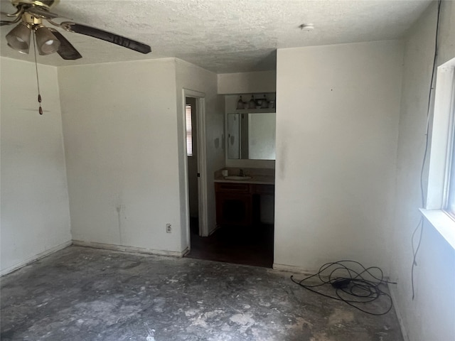 unfurnished room with sink, a textured ceiling, and ceiling fan