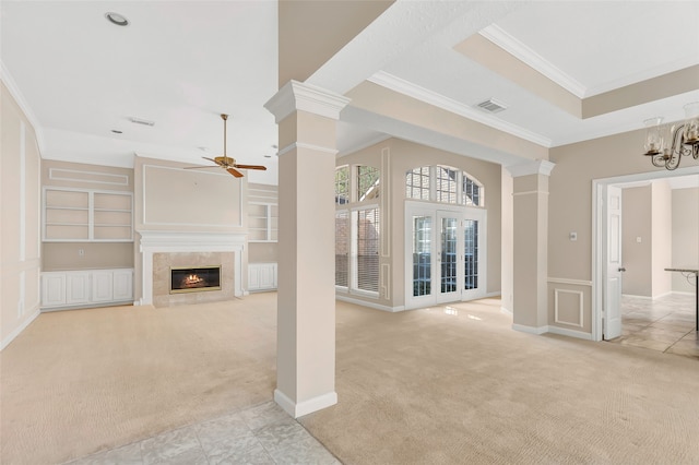 unfurnished living room featuring light carpet, crown molding, ceiling fan, and a high end fireplace