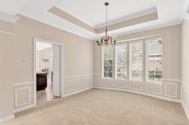 carpeted empty room with ornamental molding and a chandelier