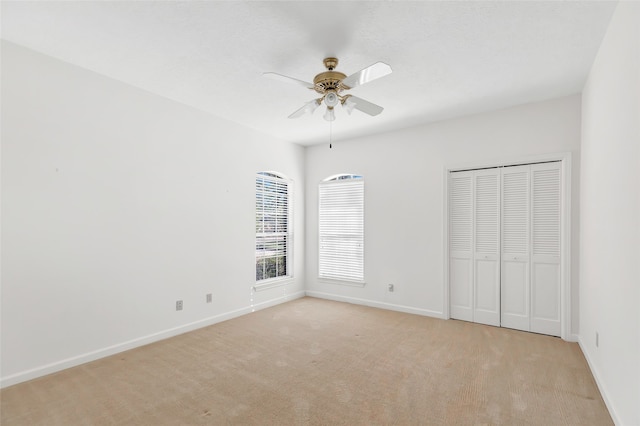 unfurnished bedroom featuring ceiling fan and light colored carpet