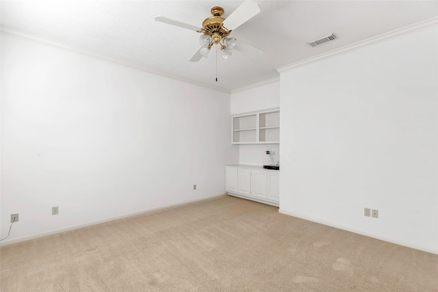 carpeted empty room with crown molding and ceiling fan