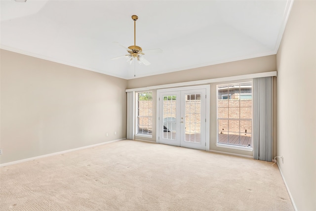 carpeted spare room with ornamental molding, a healthy amount of sunlight, ceiling fan, and french doors