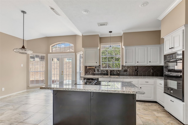 kitchen with white cabinets, double oven, light stone countertops, and pendant lighting