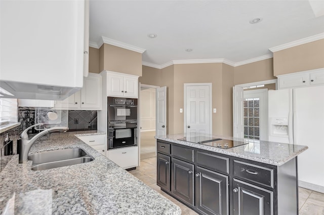 kitchen with black appliances, decorative backsplash, a center island, sink, and white cabinetry